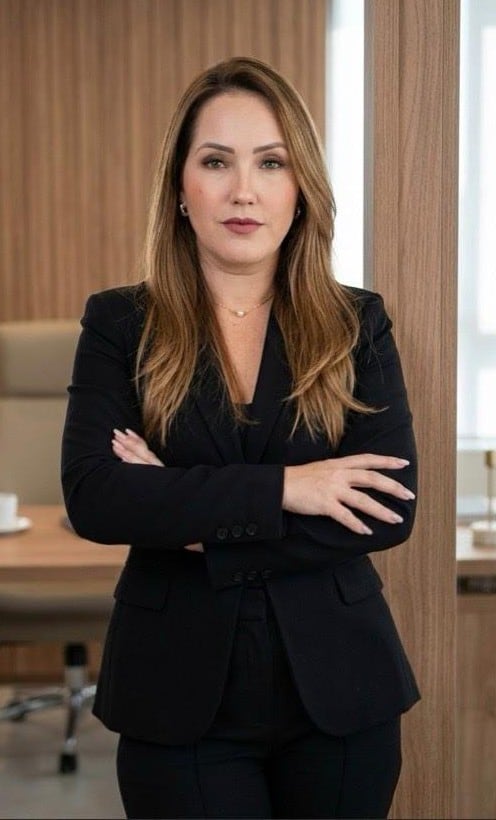 Dra. Elizandra Freitas, advogada em Goiânia, de braços cruzados em seu escritório